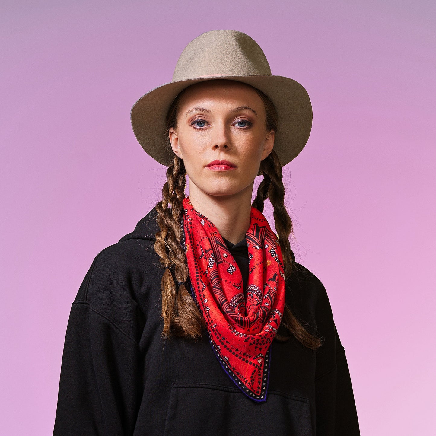 RFrau mit beigem Tuch trägt rotes Bandana-Tuch mit buntem Paisley-Muster, geometrischen Formen und lila Rand