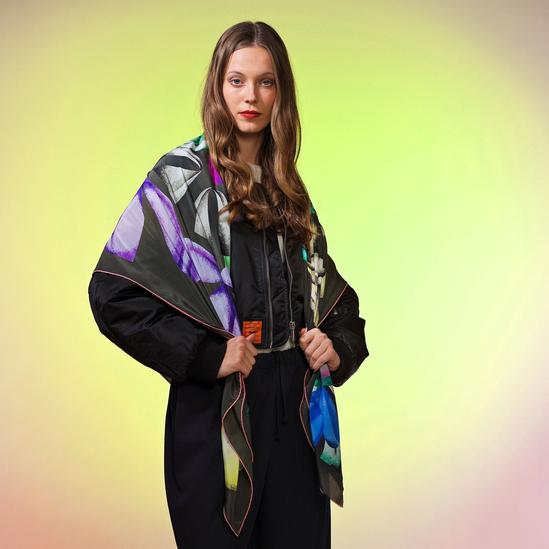 Frau trägt grosses Wolltuch mit buntem Muster auf dunklem Hintergrund, Foulard aus 100 % Seide Damen Femme Schweizer Design