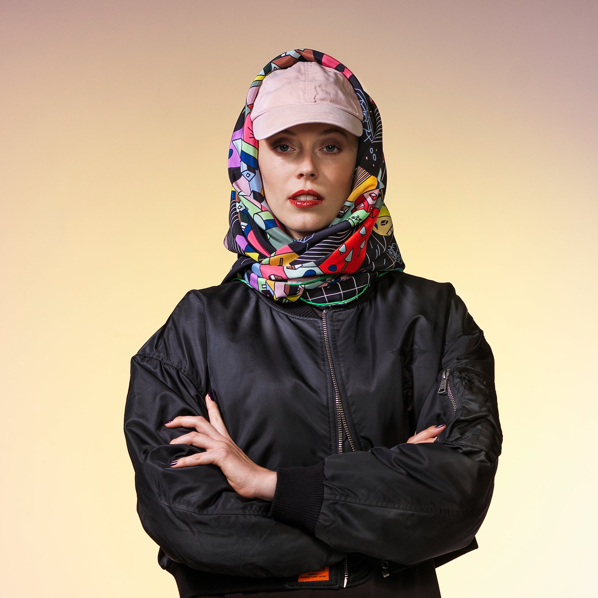 Frau mit schwarzer Bomberjacke trägt ein Seidentuch mit buntem abstraktem Lego Muster, Stadtmotiv, CITY-AMA Design, quadratisch, gross