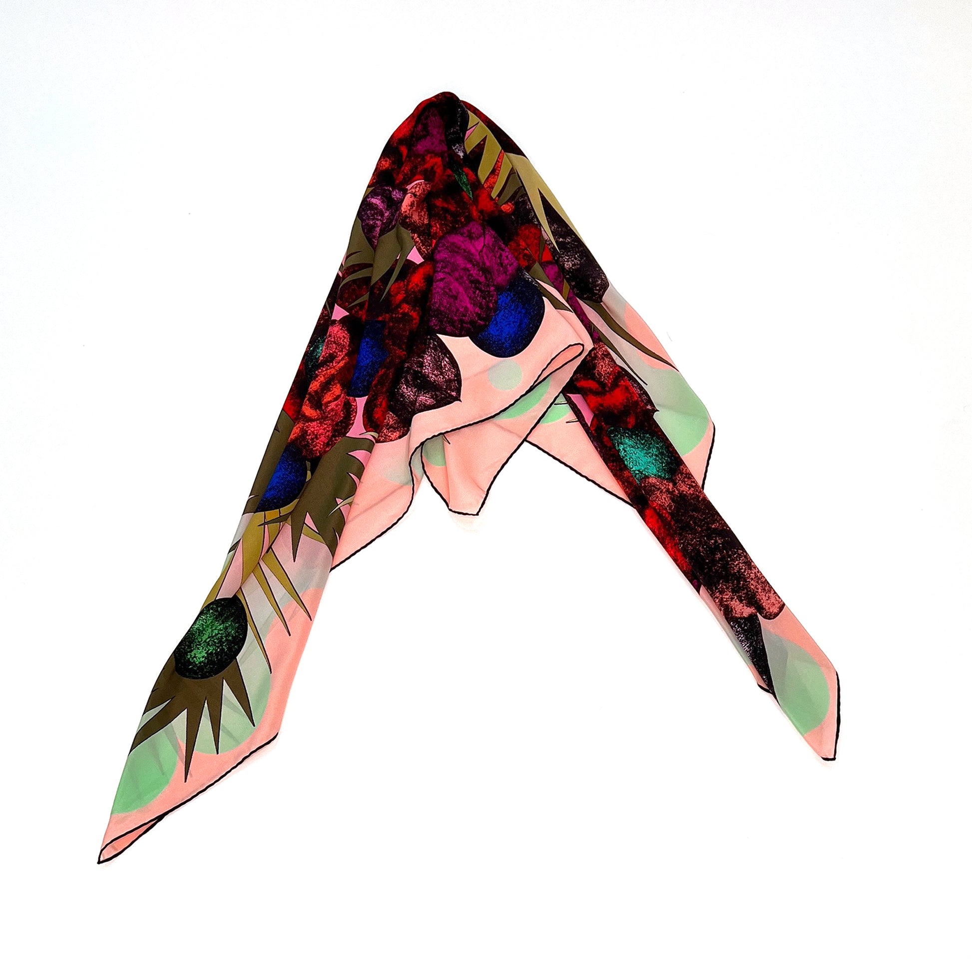 Buntes Tuch mit wildem Blumenmuster in Rot, Lila, Blau und Grün auf hellem Hintergrund